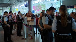 Wartende Reisende und Polizei am Düsseldorfer Flughafen