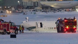 Ein Flugzeug liegt umgekippt auf der Landebahn des Flughafen Toronto