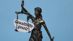 Justitia mit Schriftzug Gewalthilfegesetz 