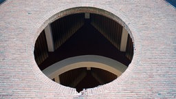 Handwerker haben das wertvolle, runde Kirchenfenster feinsäuberlich ausgebaut. Zurückgeblieben ist ein großes Loch in der Kirchenfassade. 