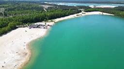 Ein Luftbild des Silbersee II mit seinem blau-grünem Wasser und langem Sandstrand