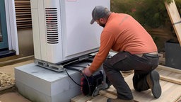 Handwerker installieren eine moderne Wärmepumpe in einem Haus, AI erzeugt