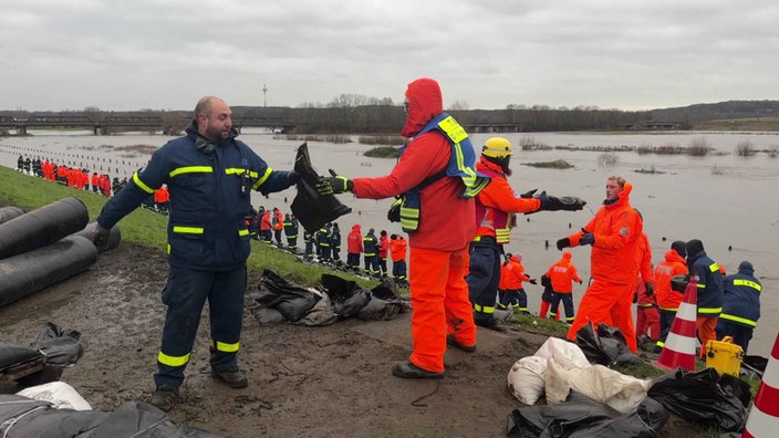 Hochwasser in Oberhausen: Viele Personen arbeiten am Deich 