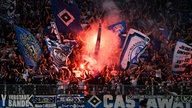 HSV-Fankurve mit Pyrotechnik und wehenden Fahnen im Stadion