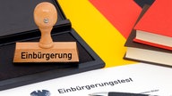 Stempel "Einbürgerung" steht neben Einbürgerunstest