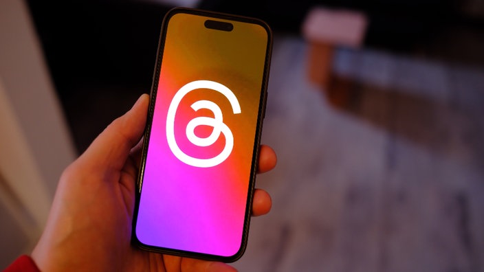 Auf einem Smartphone ist das Logo der Plattform "Threads" zu sehen