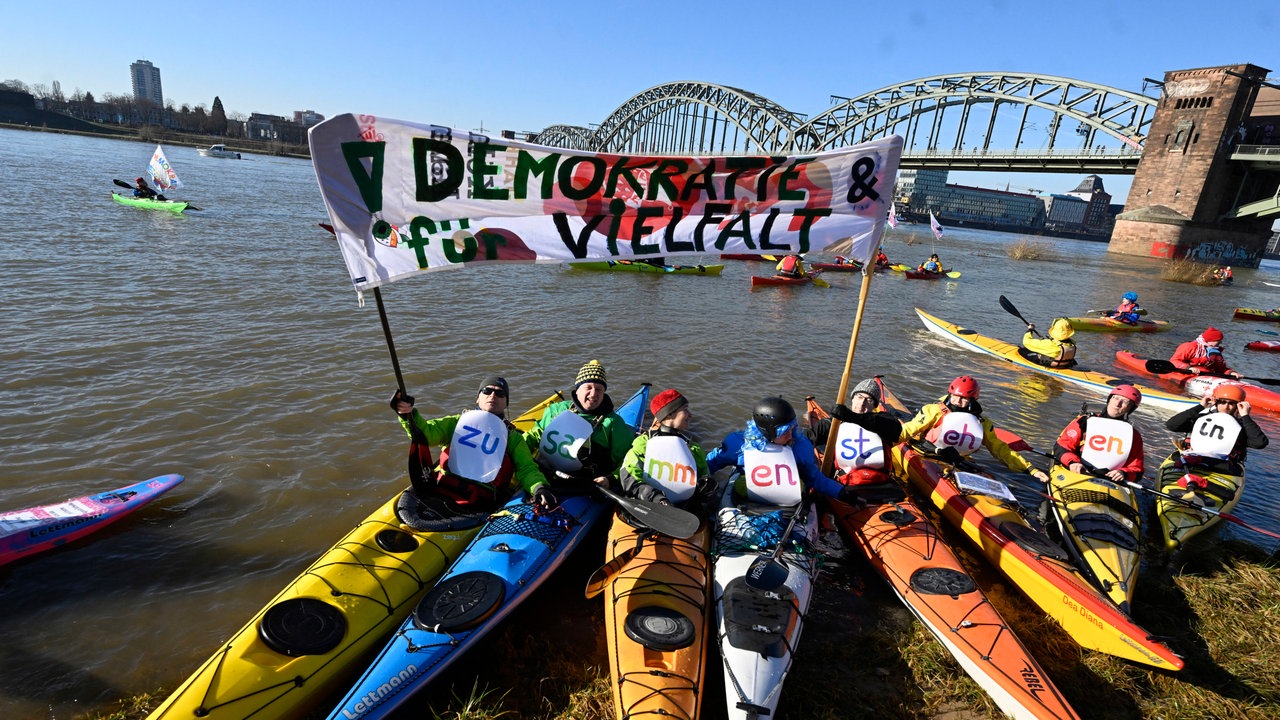 Kanuten haben sich zur Demonstration zur Migrationspolitik am Rhein versammelt