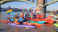 Demonstranten fahren mit Kanus und Kayaks über den Rhein