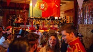 Feiernde Jecken in einer Kneipe mit Portugalflagge