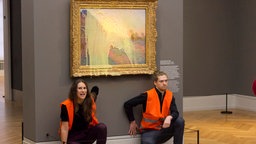 Klimaaktivisten der Klimaschutz-Protestgruppe «Letzte Generation», nachdem sie das Gemälde «Getreideschober» (1890) von Claude Monet im Potsdamer Museum Barberini mit Kartoffelbrei beworfen haben.