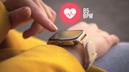 Smartwatch am Handgelenk einer Frau. Anzeige: 85 bpm