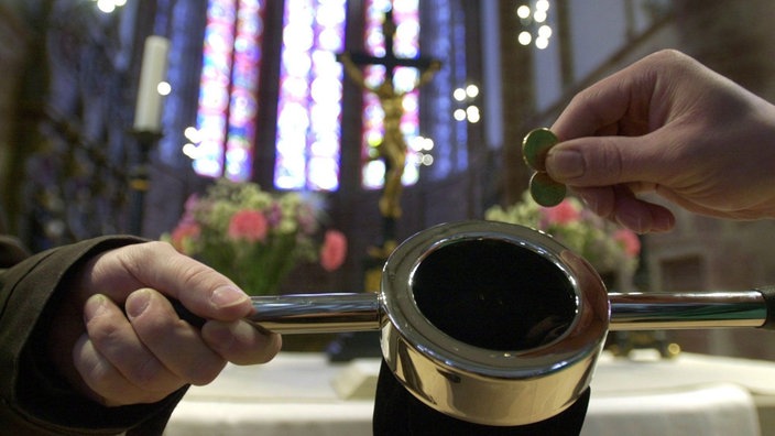 Kirchenbesucher wirft Kollekte in Klingelbeutel