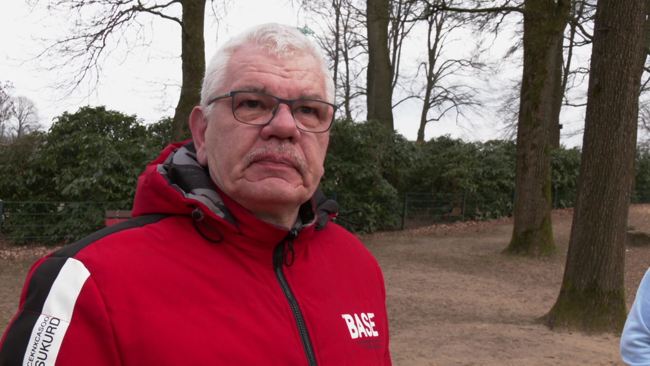 Ein Mann mit grauen Haaren und roter Jacke