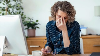 Gestresste Frau am Schreibtisch