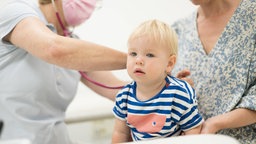 Ein Kleinkind, das von seinem Kinderarzt untersucht wird.