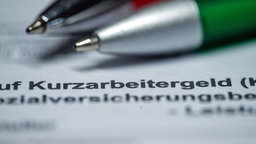 Ein Kugelschreiber auf einem Blatt Papier, das Wort "Kurzarbeitergeld" ist innerhalb eines Textes zu lesen.