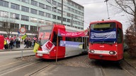 Zwei Straßenbahnen mit Streik-Bannern 