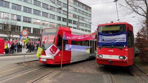 Zwei Straßenbahnen mit Streik-Bannern 