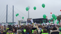 Blick auf die Menschenmenge der Demonstrierenden und die Großbildleinwand, auf der NRW-Sozialminister Karl-Josef Laumann zu sehen ist