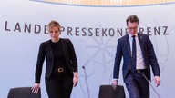 Mona Neubaur und Hendrik Wüst nehmen in der Landespressekonferenz Platz