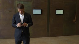 Martin Vincentz schau auf sein Smartphone