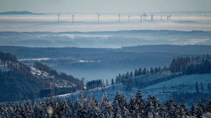 Windräder ragen vom Kahlen Asten aus gesehen aus dem Nebel.