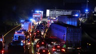 Ein Lastwagen (hinten) steht auf der Autobahn 1 bei Hagen an der Unfallstelle während sich ein Stau gebildet hat