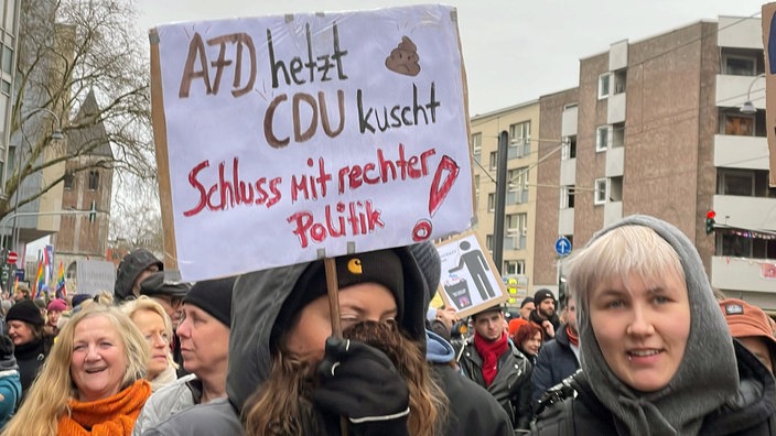 ei einer Demonstration gegen Rechts in Köln zeigen Teilnehmer ein Plakat mit der Aufschrift "AfD hetzt, CDU kuscht - Schluss mit rechter Politik