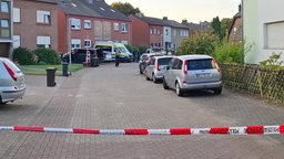 Polizeiwagen hinter einer Absperrung in einem Wohngebiet in Moers