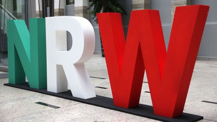 Das Logo des Bundeslandes Nordrhein-Westfalen mit den Buchstaben NRW steht im Foyer des Innenministeriums