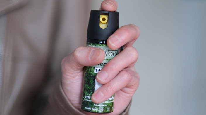  Eine Hand hält eine Kartusche mit Pfefferspray