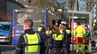 Einsatzkräfte stehen um einen Bus 