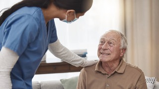 Aufnahme einer jungen Krankenpflegerin mit einem älteren Patienten