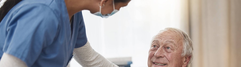 Aufnahme einer jungen Krankenpflegerin mit einem älteren Patienten