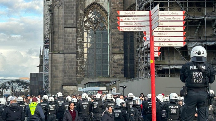 Ein Team von Polizisten sperrt den Platz vor dem Kölner Dom ab