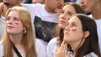 Drei Frauen mit Deutschland-Bemalungen im Gesicht schauen das EM-Viertelfinale Deutschland-Spanien beim Public Viewing in Köln am Heumarkt