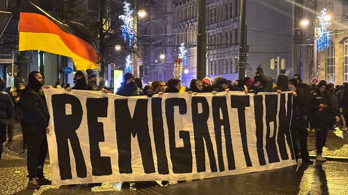 "Remigration" steht auf einem Banner bei einer Demonstration rechter Gruppierungen.