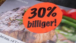 Aufkleber 30 % billiger auf einer Packung Fleisch vom Discounter