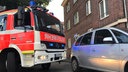 Ein Feuerwehrwagen und ein Auto stehen in einer engen Straße