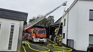 Feuerwehrauto im Einsatz mit ausgefahrener Leiter 