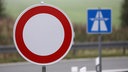 Im Vordergrund ist ein Sperrschild, dahinter ein Autobahnschild zu sehen 