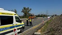 Zwei Polizisten stehen auf der Autobahn neben einem Wagen mit der Aufschrift "Unfallaufnahme"