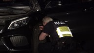 Ein Polizist kontrolliert ein Auto. 