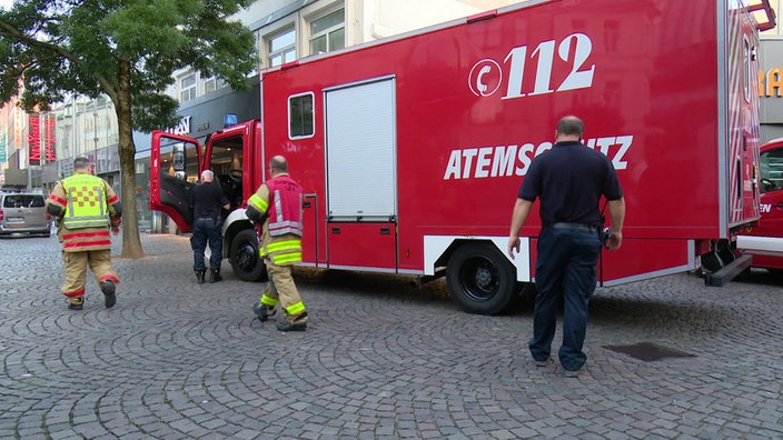 Einsatzkräfte vor einem Feuerwehrfahrzeug