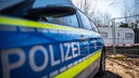 Ein Polizeiauto steht vor einem abgesperrten Wohnwagen auf dem Campingplatz Eichwald in Lügde