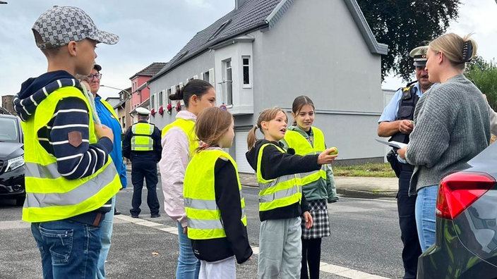 Schulkinder verteilen Zitronen an eine Autofahrerin in Düren