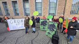 Demonstrierende stehen vor dem Gebäude