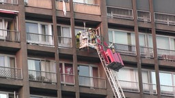 Feuerwehrmänner bergen Personen aus dem Hochhaus