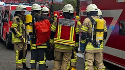 Feuerwehrleute in Schutzkleidung und mit Sauerstoffgeräten.