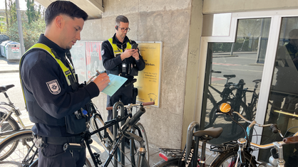 Mitarbeiter des Ordnungsamtes markieren Fahrräder, die nicht mehr fahrbereit sind.